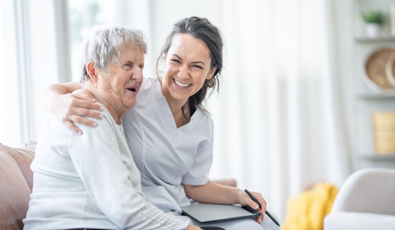 A lady and carer having fun in a care home