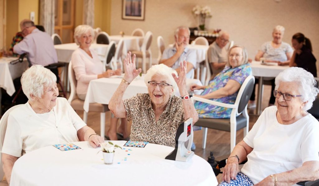 Elderly people playing bingo and fun activities in a care home